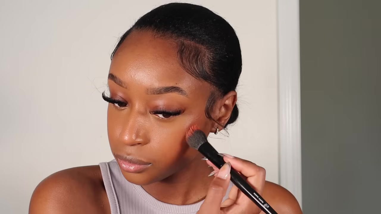 Fatima Bah demonstrating tap on orange-toned liquid blush