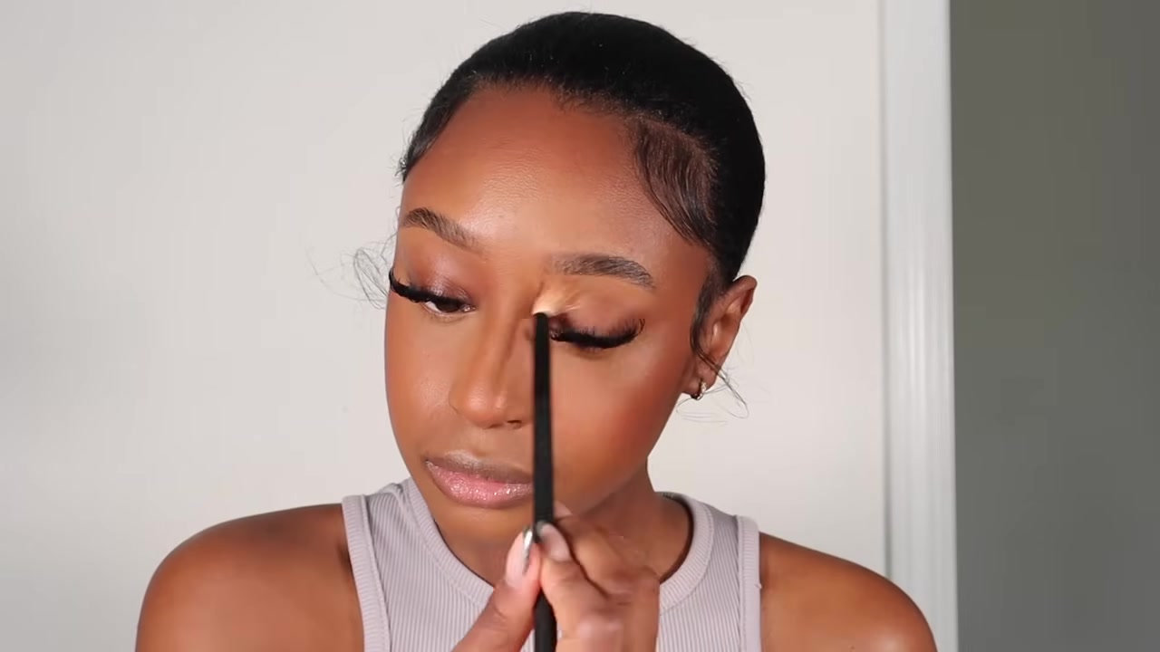 Fatima Bah demonstrating warm the face and reuse bronzer on the eyes